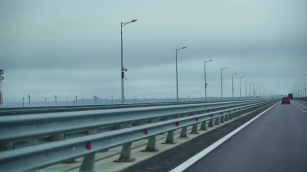 Une voiture conduisant le long d'une grande route vide tôt le matin par temps nuageux. Point de vue du conducteur, vue intérieure d'une voiture sur l'autoroute — Video