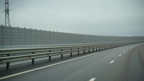 Um carro dirigindo ao longo de uma ampla estrada vazia no início da manhã em tempo nublado. Ponto de vista de condução, vista interior de um carro na Autobahn — Vídeo de Stock