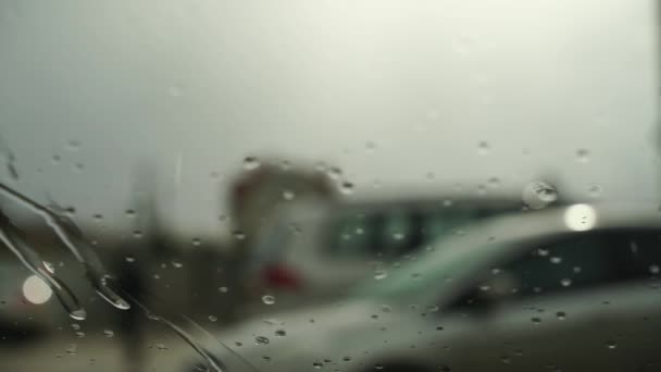 Water druppels uitzicht vanuit de auto. Het regent, andere auto 's zijn zichtbaar vanuit het raam. — Stockvideo