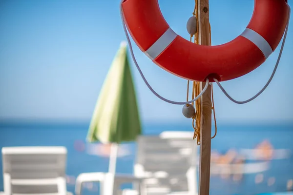 Diversi lettini bianchi e una boa di salvataggio su una spiaggia deserta. Il concetto di vacanza perfetta — Foto Stock