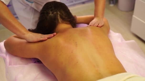 Junge unkenntliche Frau bekommt professionelle Rückenmassage im Wellness-Salon. Schöne nackte Dame mit perfekter Haut bekommt eine entspannende Massage. Konzept der professionellen Luxus-Massage — Stockvideo