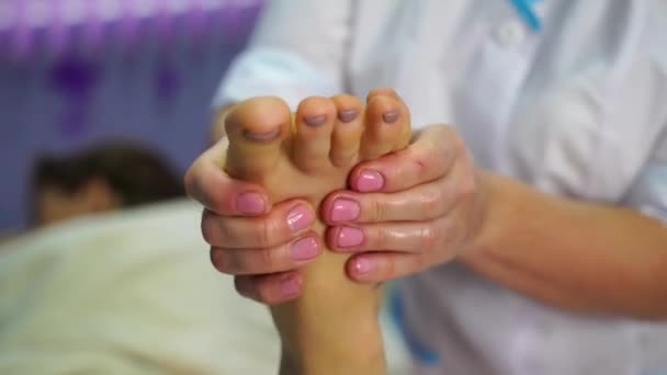 Γυναίκα που κάνει μασάζ στα γυμνά της πόδια σε ένα σπα. Μασάζ ποδιών με λάδι στο σπα του θέρετρου. χαλάρωση της υγείας του δέρματος. — Αρχείο Βίντεο