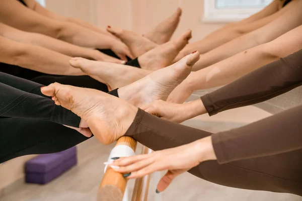 Legs of ballerinas on the barre in the training room — Stock Photo, Image