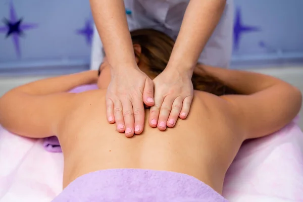 Visão superior das mãos massageando o abdômen feminino.Terapeuta aplicando pressão na barriga. Mulher recebendo massagem no salão de spa — Fotografia de Stock