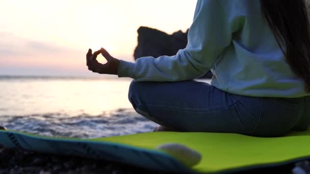 Vista posteriore di una giovane bella donna caucasica che pratica yoga sulla spiaggia al mare. Yoga. Uno stile di vita sano. Concetto di meditazione. — Video Stock