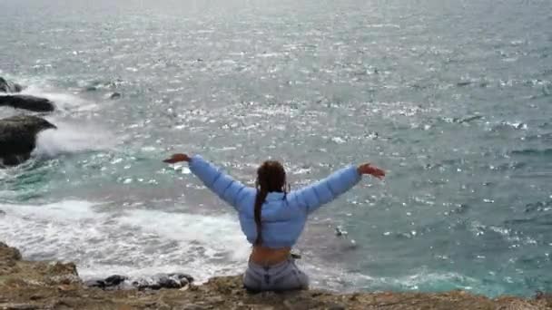 Žena Modrém Saku Sedí Skále Nad Útesem Nad Mořem Dívá — Stock video