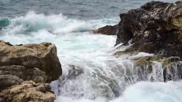 Rallentatore statico delle onde oceaniche che vorticano e si schiantano e coprono rocce — Video Stock