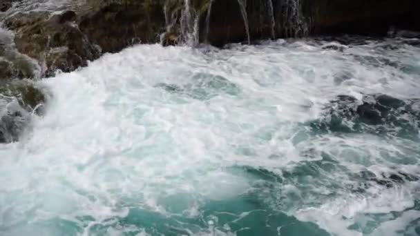 Zeitlupenstatik von Meereswellen, die wirbeln und krachen und Felsen bedecken — Stockvideo