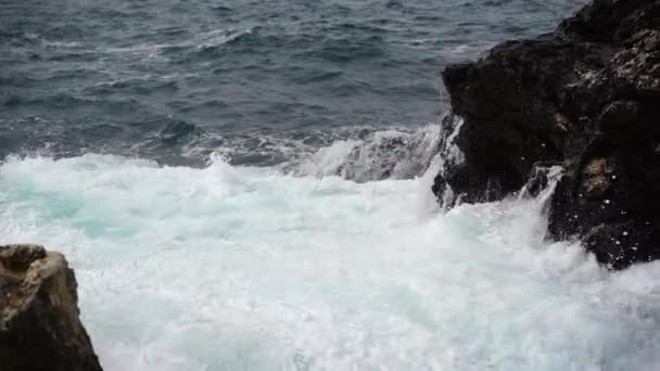 Yavaş hareket eden okyanus dalgaları kıvrılıyor, çarpıyor ve kayaları kaplıyor. — Stok video