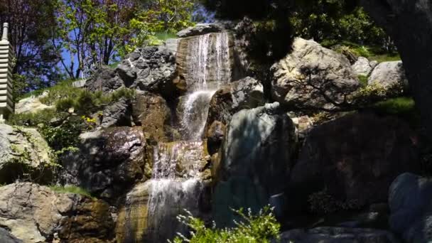 在日本花园的瀑布中 水缓缓地从火山岩上流过 — 图库视频影像