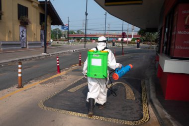 CHIANGMAI, THAILAND-APRIL 30, 2022 : Staff PPE uniforms suit are using an alcohol sprayer to clean the coronavirus in the street. Chiang Mai , Thailand.