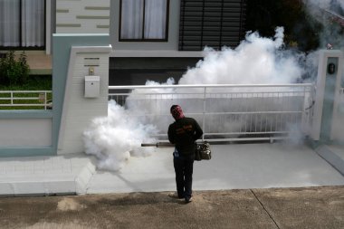 CHIANGMAI - 24 Haziran 2022: Sivrisinekleri öldürmek için sprey kimyasal madde kullanan bir adam, Chiangmai, Tayland 'da sivrisinekleri öldürmek için duman püskürtüyor.. 
