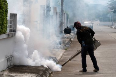 CHIANGMAI - 24 Haziran 2022: Sivrisinekleri öldürmek için sprey kimyasal madde kullanan bir adam, Chiangmai, Tayland 'da sivrisinekleri öldürmek için duman püskürtüyor.. 
