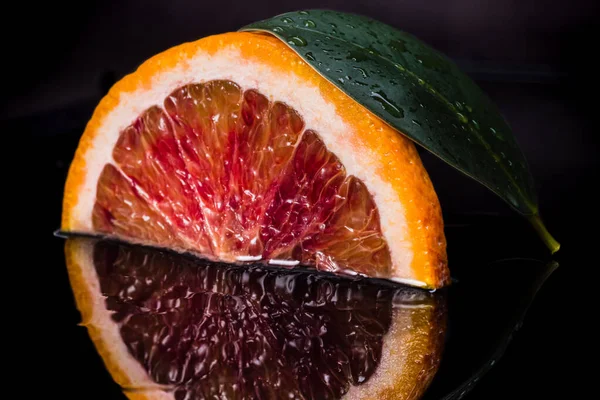 Rebanada Fruta Naranja Siciliana Roja Hoja Verde Sobre Fondo Negro — Foto de Stock