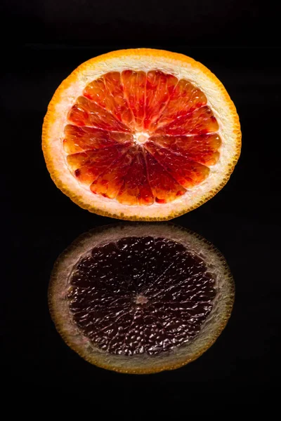 Fruta Naranja Siciliana Roja Cortada Dos Sobre Fondo Negro Reflectante — Foto de Stock