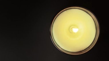 Siyah arka planda yanan aroma mumu. Mum ışığı, yüksek çerçeve üzerinde yakın çekim yapar. Fotokopi alanı olan yeşil aroma mumunun ateşlenmesi