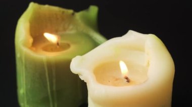 Siyah arka planda mumları yakıyorum. Yeşil ve beyaz balmumu mumlar yüksek çerçeve ile filme alınır. Üzüntü sembolü
