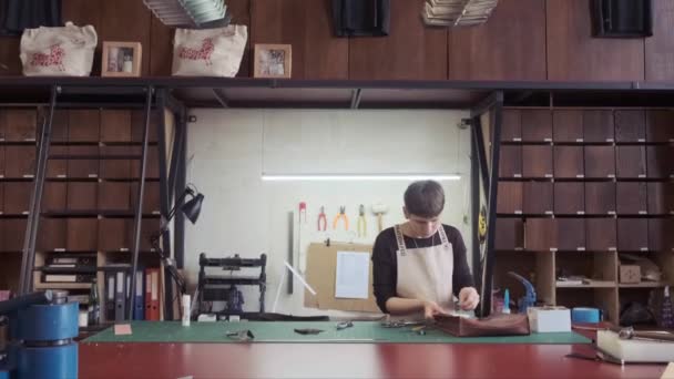 革製造ワークショップ 若い女性の仕立屋は革手作りのバッグ 工房で働く革職人 — ストック動画