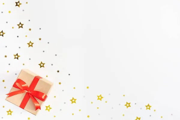 Geschenkschachtel mit roter Schleife, Sterne auf weißem Hintergrund. — Stockfoto