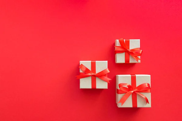 Tres regalos sobre un fondo rojo. — Foto de Stock