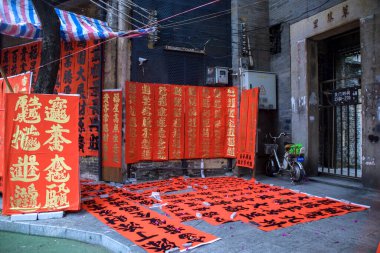 Foshan, Guangdong bölgesi, Çin. Ocak 14, 2022. İnsanlar Bahar Festivali için tebrik mektupları yazıyor. Foshan 'daki Kuaizi caddesinde Çin Yeni Yıl kutlamaları için hazırlık