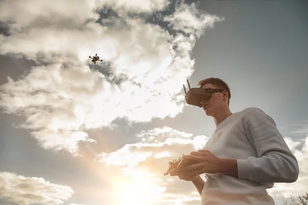 Drone quadrocopter flying, man operates in digital glasses hands outdoors. Young man releasing aerial copter to fly with small flying camera. Concept of modern technology in our life. Copy space