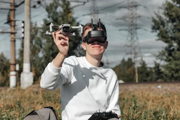 Drone quadrocopter flying, man operates in digital glasses hands outdoors. Young man releasing aerial copter to fly with small flying camera. Concept of modern technology in our life. Copy space