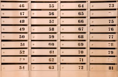 Bir apartmandaki çelik posta kutuları. Hatta sıra sıra numaralandırılmış posta kutusu. Şehirdeki yazışma konsepti. Bunu yaratıcılığın için arka plan olarak kullanabilirsin. Boşluğu kopyala