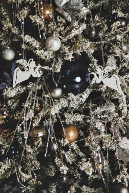 Noel tatili arka planında Noel baloları ve oyuncaklarla süslenmiş bir ağaç var. Mutlu yıllar konsepti. İç mekanda yakın plan dekor. Alan için kopyala