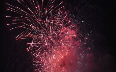 Kara gece gökyüzü evreninde kıvılcımları, renkli yıldızları ve parlak nebulası olan bayram havai fişekleri, kuyruklu yıldızları. İnanılmaz güzel, renkli havai fişekler kutlamada, gösterimde. Tatil geçmişleri