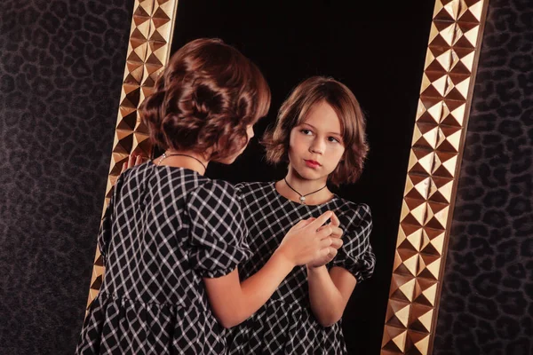 소녀가 어여쁜 실내의 어두운 스타일의 거울에우아 드레스를 어린이들의 스타일 — 스톡 사진