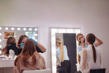 Makyaj sanatçıları genç kadınları güzellik salonunda yaparlar. Harika bir imaj yaratmak için müşteri hizmetleri iç odada. Yaratılış büyücüsüyüm. Tarz ve memnuniyet kavramı. Boşluğu kopyala