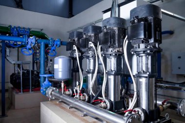Su pompasının, vanaların, basınç göstergelerinin, makine dairesinin içindeki motorların endüstriyel içleri. Endüstriyel bir odada valf ve pompalar. Kentsel modern güçlü boru hatları ve pompalar, otomatik kontrol sistemleri