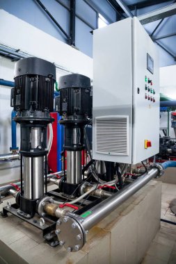 Su pompasının, vanaların, basınç göstergelerinin, makine dairesinin içindeki motorların endüstriyel içleri. Endüstriyel bir odada valf ve pompalar. Kentsel modern güçlü boru hatları ve pompalar, otomatik kontrol sistemleri