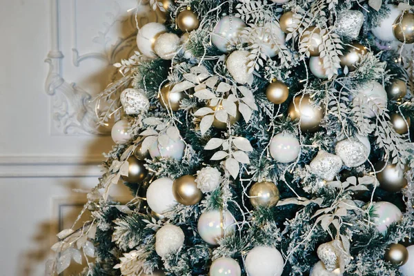 Noel tatili arka planında Noel baloları ve oyuncaklarla süslenmiş bir ağaç var. Mutlu yıllar konsepti. İç mekanda yakın plan dekor. Alan için kopyala