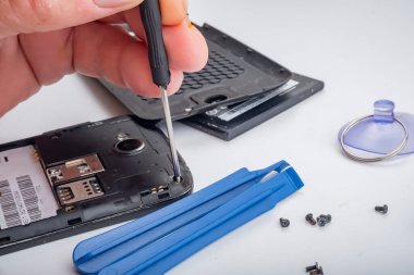 Usta, aletlerin yardımıyla bozuk bir akıllı telefonu tamir eder..