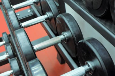 Fitness dersleri için halterler düzgünce yerleştirilmiştir. Fitness, atletizm, güç egzersizleri.