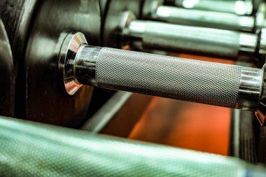 Fitness dersleri için halterler düzgünce yerleştirilmiştir. Fitness, atletizm, güç egzersizleri.