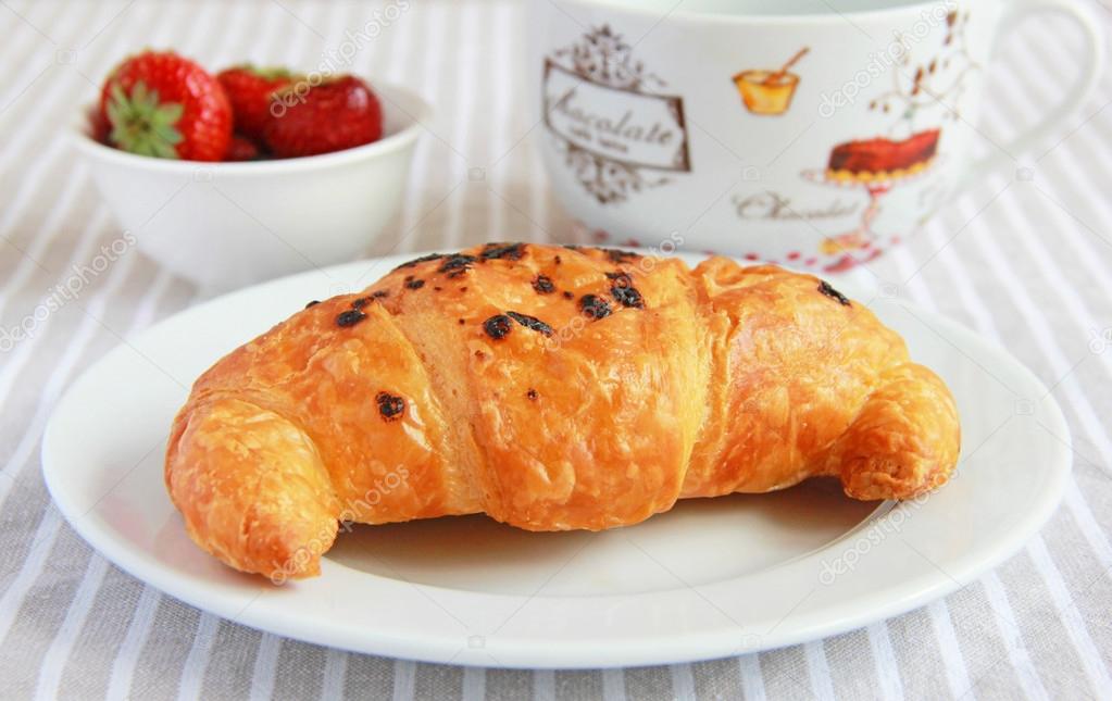 Croissants with chocolate and strawberries for breakfast
