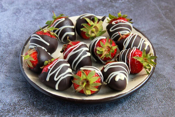 Chocolate covered strawberries. Homemade sweets made of strawberry covered in belgian chocolate and decorated with white chocolate.