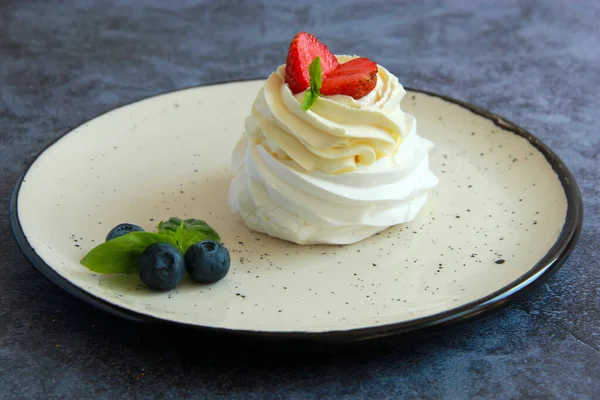 Tabakta ev yapımı Pavlova tatlısı. Kremalı Meringue Pavlova. Taze böğürtlen ve nane ile süslenmiş..