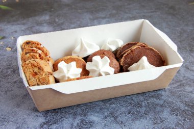 Tabakta çeşitli kurabiyeler var. Taze ev yapımı kurabiyeler: bisküviler, çikolatalı kurabiyeler, şekerli kurabiyeler, meringe, fındıklı kurabiyeler, karamel kurabiyeleri, kakao kurabiyeleri