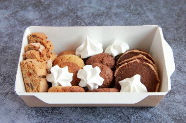 Tabakta çeşitli kurabiyeler var. Taze ev yapımı kurabiyeler: bisküviler, çikolatalı kurabiyeler, şekerli kurabiyeler, meringe, fındıklı kurabiyeler, karamel kurabiyeleri, kakao kurabiyeleri