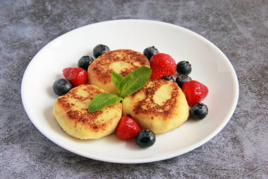 Tofudan yapılmış vejetaryen şurubu. Taze böğürtlenlerle süslenmiş ev yapımı tofu peynirli kek sosu. Sağlıklı vejetaryen kahvaltısı.