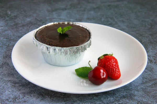自制的巧克力熔岩蛋糕 罐头里有冰淇淋和新鲜的浆果 盘子里有巧克力粉 — 图库照片