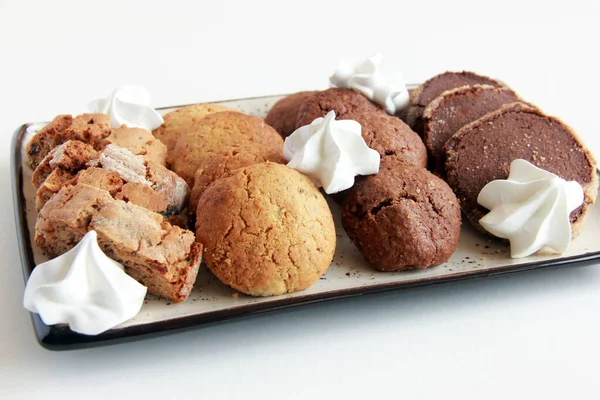 Assorted cookies on the plate. Fresh homemade cookies: biscotti, chocolate cookies, sugar cookies, meringe, nut cookies, caramel cookies, cocoa cookies