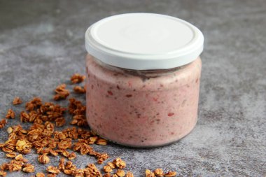 Çilekli ve hindistan cevizli yulaf ezmesi. Kavanozda bir gecelik yulaf lapası, böğürtlen ve süt..