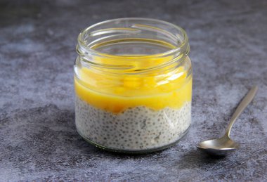 Hindistan cevizi sütü ve mango püresiyle Chia pudingi. Lezzetli vejetaryen kahvaltısı, çöl, cam kavanozda atıştırmalık.