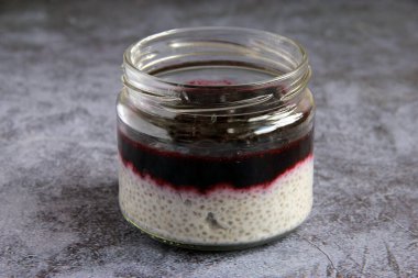 Hindistan cevizi sütü ve siyah üzümlü vejetaryen chia pudingi. Kavanozda sağlıklı vejetaryen kahvaltısı. Çilekli puding..