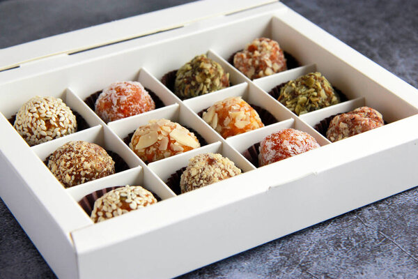 Homemade natural vegan sweets without sugar. Delicious sweets made of dry fruits and nuts in the box.